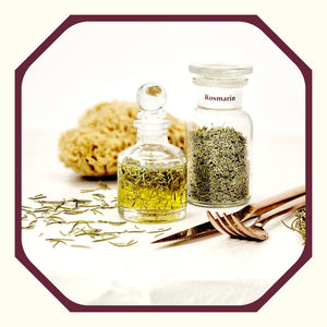 Rosmarin im Glas neben einer Flasche Rosmarinöl, einem Naturschwamm, Rosmarinnadeln, Besteck