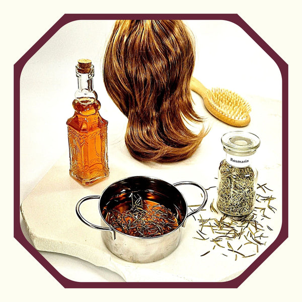 Rosmarin im Glas, daneben eine braune Frauenperücke, eine Haarbürste, eine Flasche mit Rosmarin Haarwasser, ein Topf mit Rosmarin-Haarwasser, Rosmarinnadeln